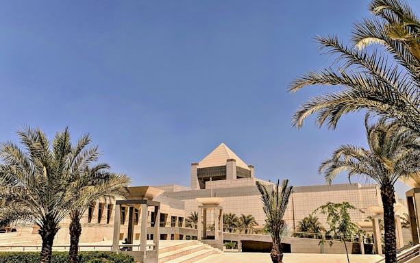 National Museum of Egyptian Civilization in Cairo with palm trees and modern architecture.