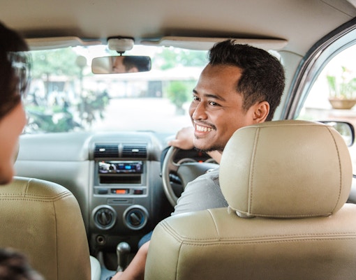 Person sitting in a taxi in New York City, looking out at Times Square.