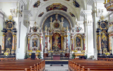 Interior of Engelberg Abbey church with ornate altar and frescoes, part of Lucerne tour.