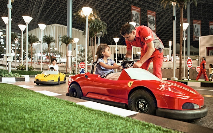 Children driving toy Ferrari cars at Ferrari World Abu Dhabi.