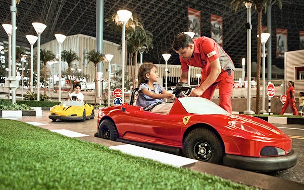 Children driving toy Ferrari cars at Ferrari World Abu Dhabi.