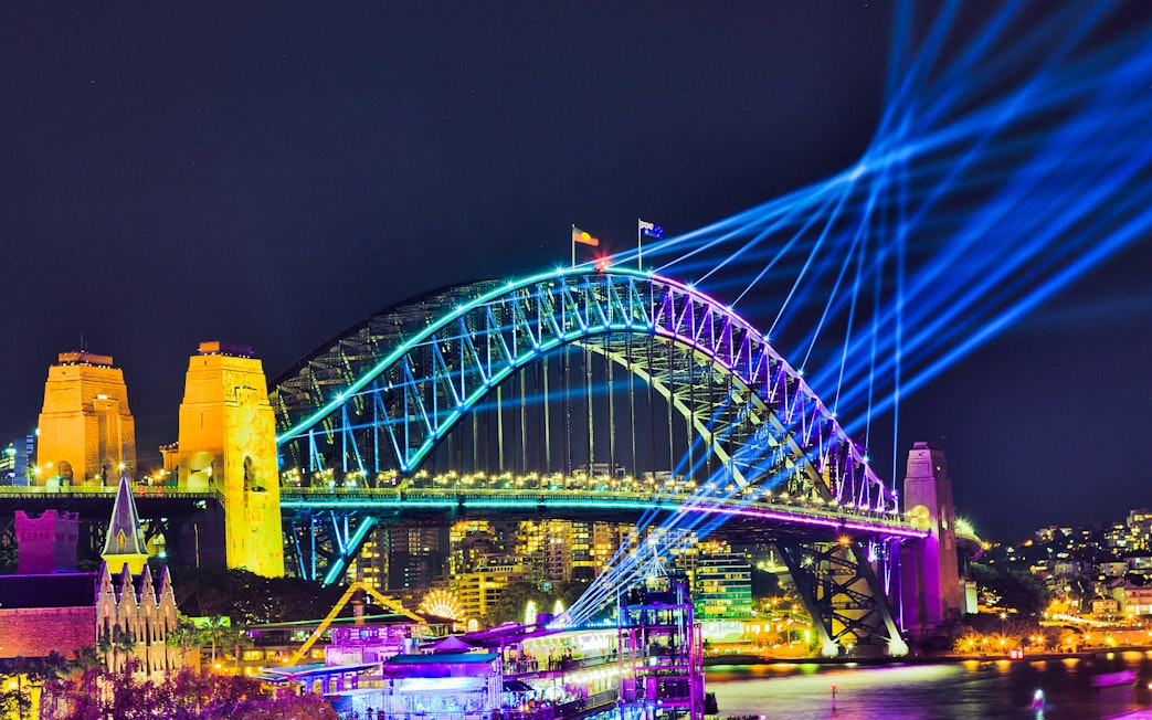 Sydney Harbour Bridge illuminated during Vivid Sydney, viewed from a tall ship dinner cruise.