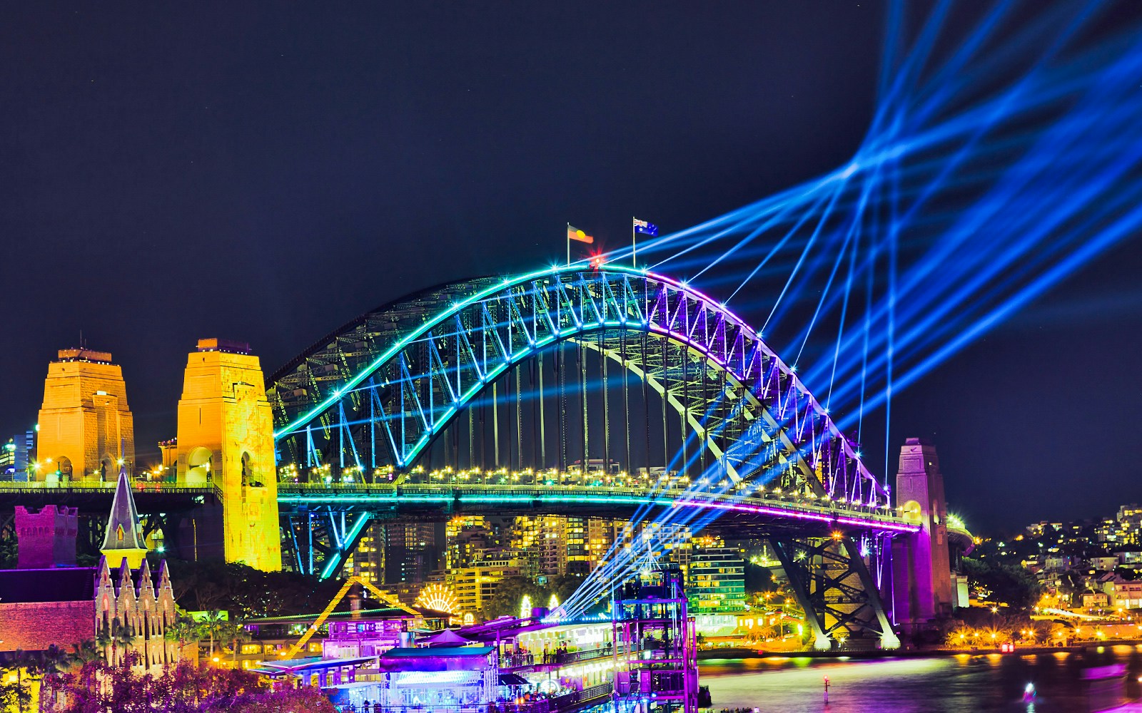 Sydney Harbour Bridge illuminated during Vivid Sydney, viewed from a tall ship dinner cruise.