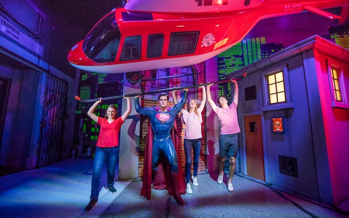 Visitors posing with Superman figure at Madame Tussauds Sydney, part of the Multi Attraction Pass.