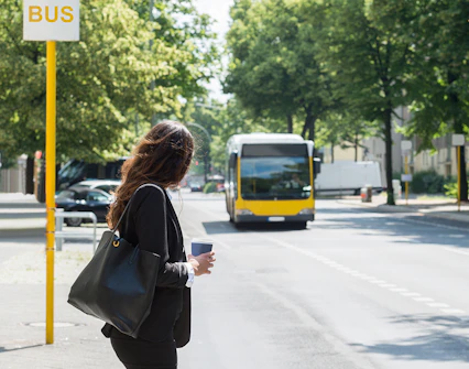 Tourist waiting at a bus stop in Barcelona with Hola Barcelona Travel Card.
