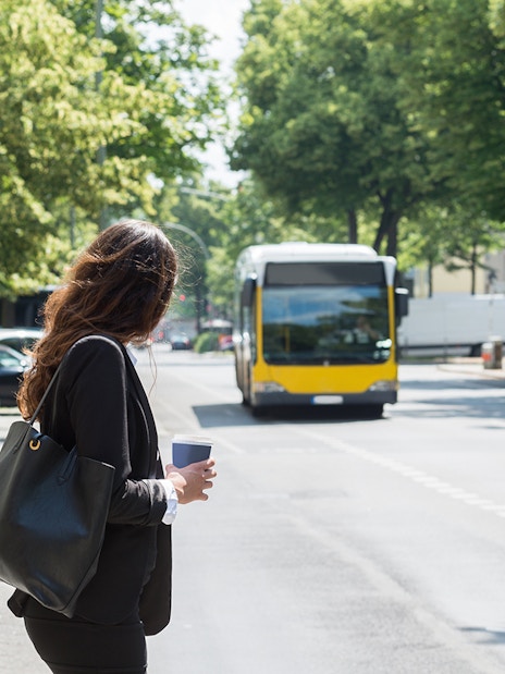 Tourist waiting at a bus stop in Barcelona with Hola Barcelona Travel Card.
