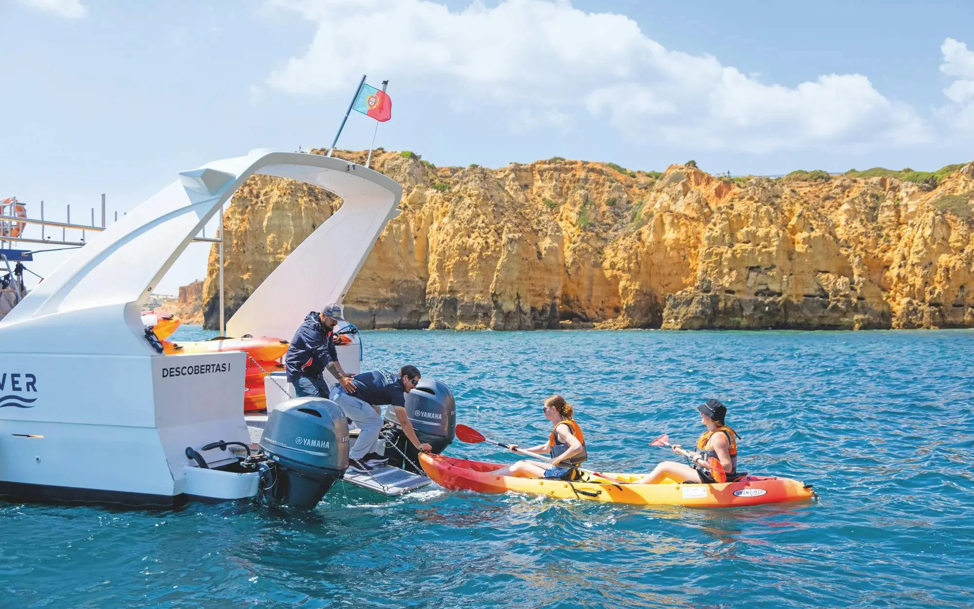 Kayakers departing from a boat near Ponta da Piedade cliffs, Algarve.