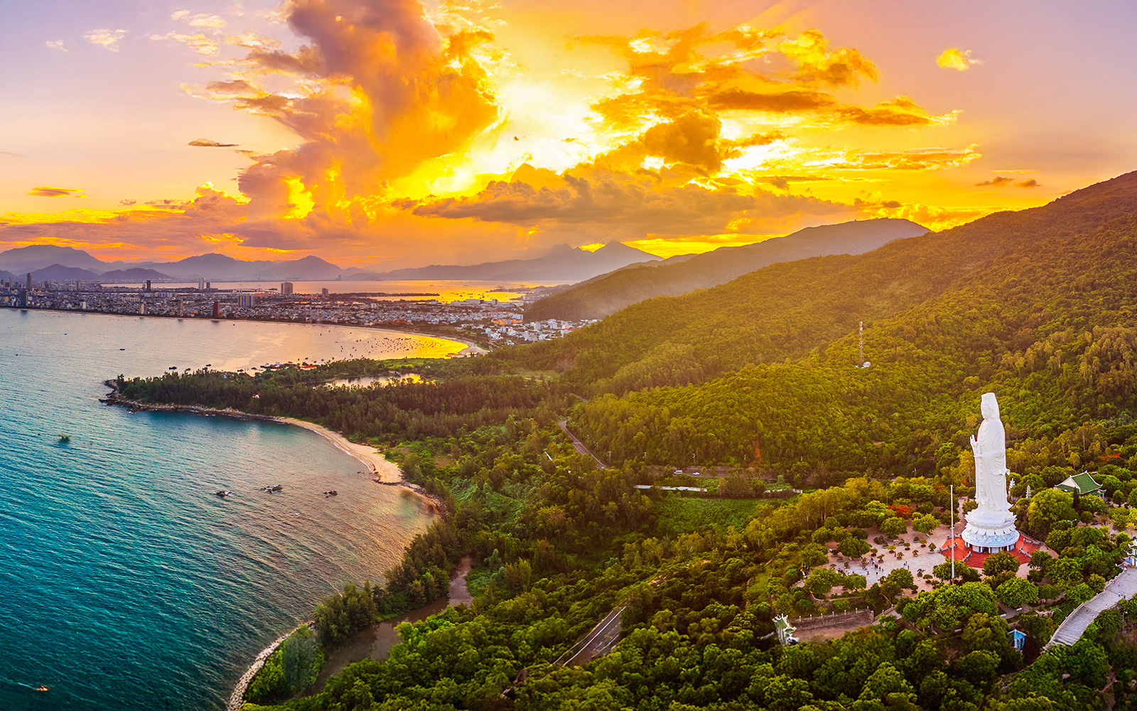 Aerial view of Sơn Trà Peninsula with Lady Buddha statue at sunset, Đà Nẵng, Vietnam.