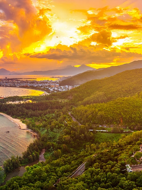Aerial view of Sơn Trà Peninsula with Lady Buddha statue at sunset, Đà Nẵng, Vietnam.
