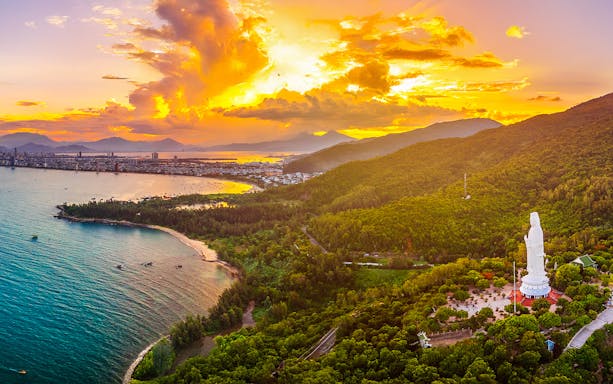 Aerial view of Sơn Trà Peninsula with Lady Buddha statue at sunset, Đà Nẵng, Vietnam.