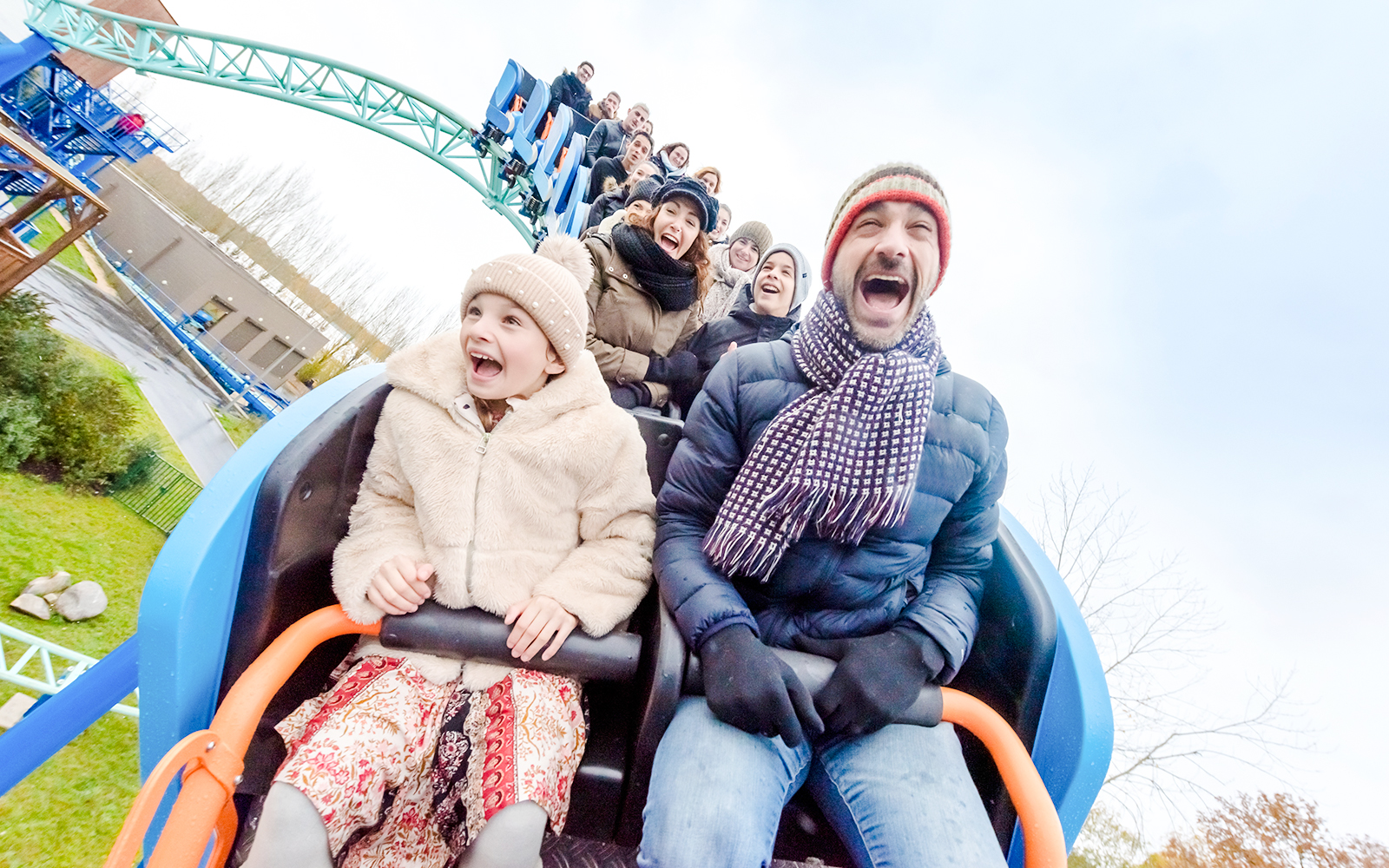 Family enjoying a roller coaster ride at Parc Asterix during Christmas celebrations.