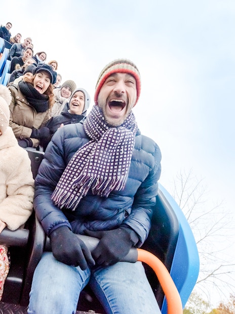 Family enjoying a roller coaster ride at Parc Asterix during Christmas celebrations.