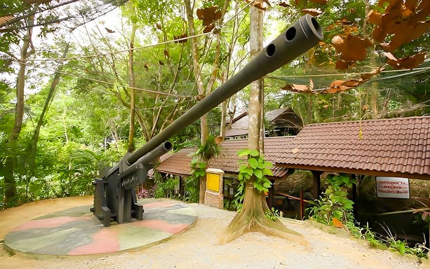 Gun emplacement at Penang War Museum surrounded by lush greenery.