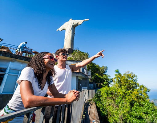 Visitors at Christ the Redeemer statue in Rio de Janeiro, Brazil, with scenic city view.
