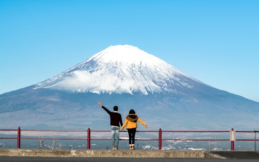 Couple admiring Mt. Fuji from Kawaguchiko viewpoint on a clear day.