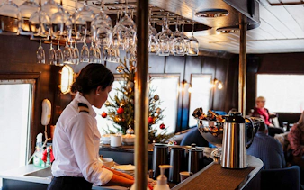 Server preparing drinks on Ålesund-Geiranger-Ålesund Fjord boat tour.