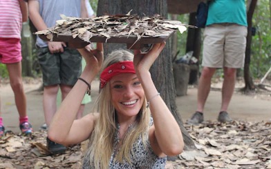 Tourist demonstrating Cu Chi Tunnels entrance during VIP PREMIUM tour in Vietnam.