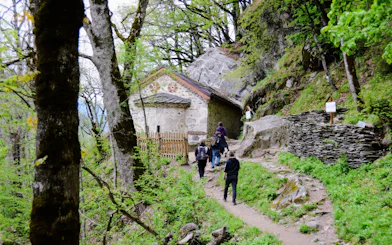 Guests walking towards St. Ivan Cave through a forested path.