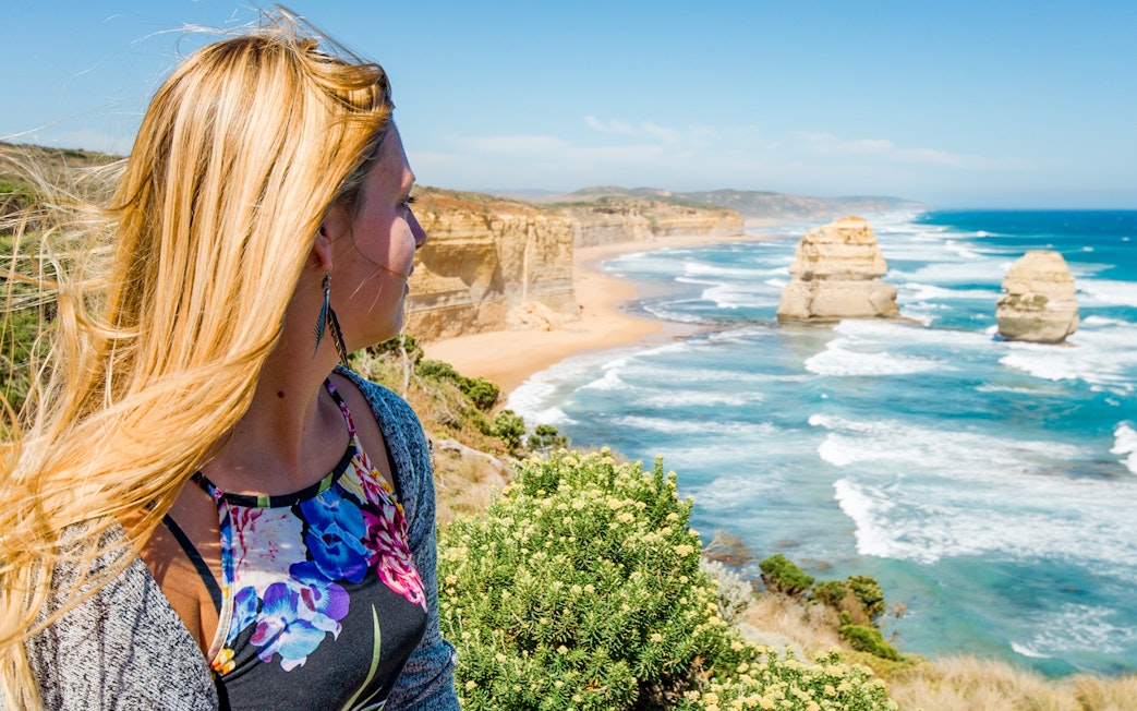 Woman gazing at Shipwreck Coast along Great Ocean Road, Australia.