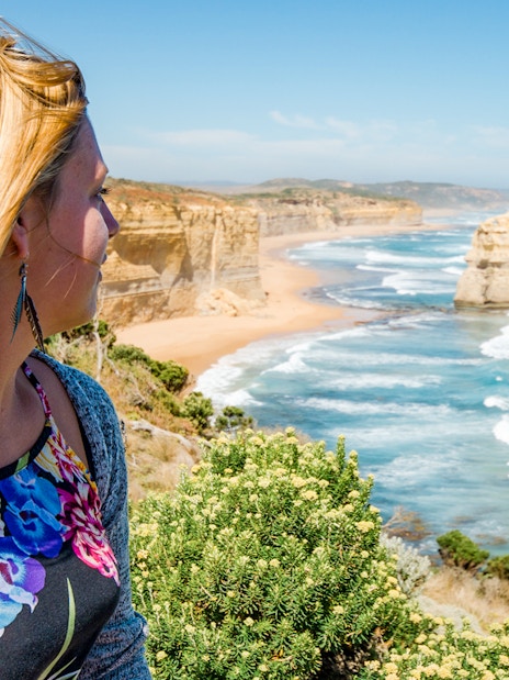 Woman gazing at Shipwreck Coast along Great Ocean Road, Australia.