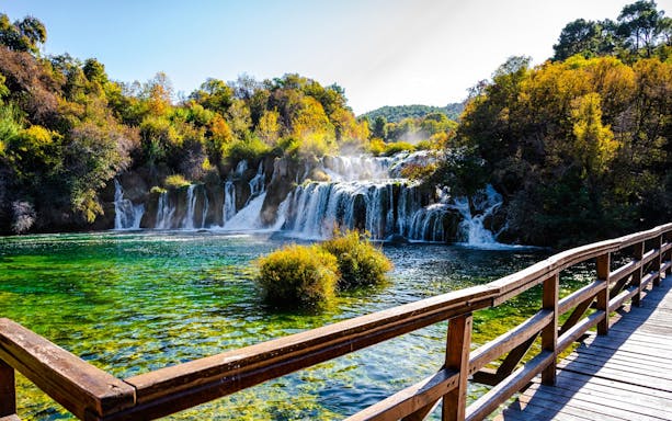 Wooden walkway overlooking waterfalls at Krka National Park, Croatia.