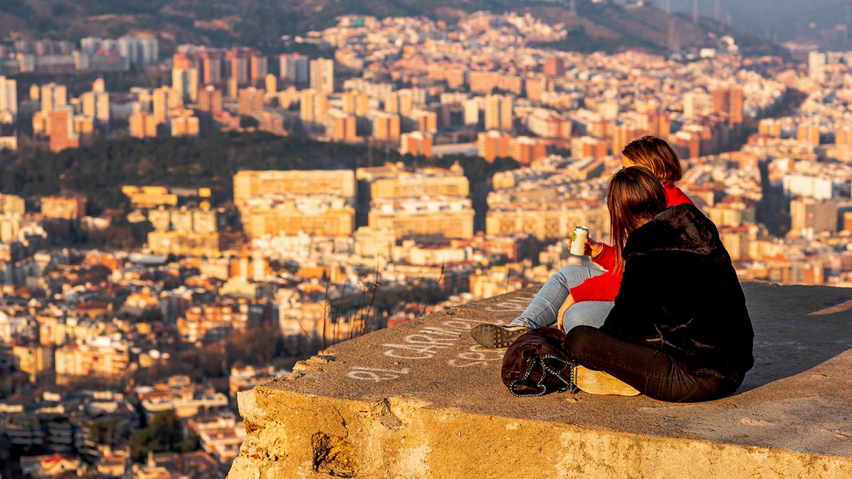 Visitors enjoying the panoramic view of Barcelona from MUHBA Turó de la Rovira viewpoint.