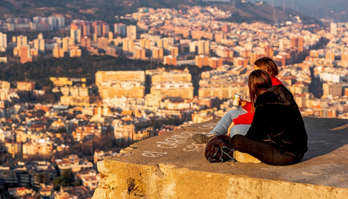 Visitors enjoying the panoramic view of Barcelona from MUHBA Turó de la Rovira viewpoint.