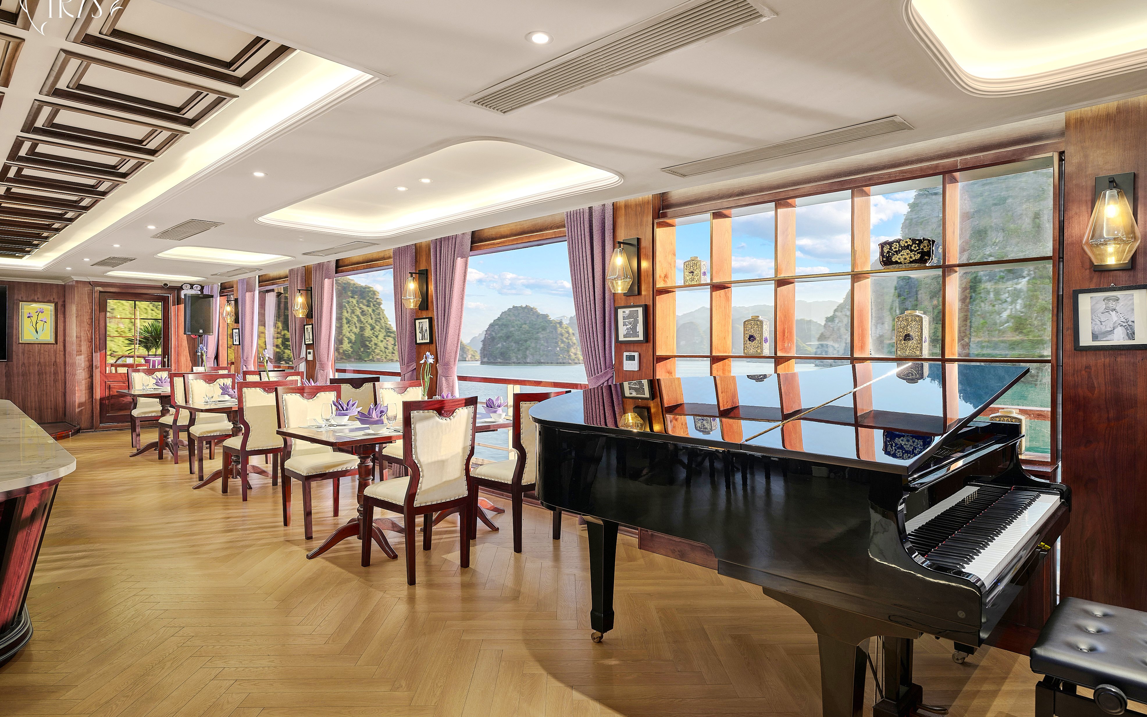 Restaurant 2nd deck with grand piano on Iris Luxury Cruise, Ha Long Bay views.
