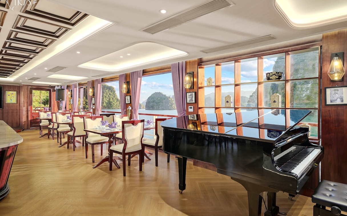 Restaurant 2nd deck with grand piano on Iris Luxury Cruise, Ha Long Bay views.