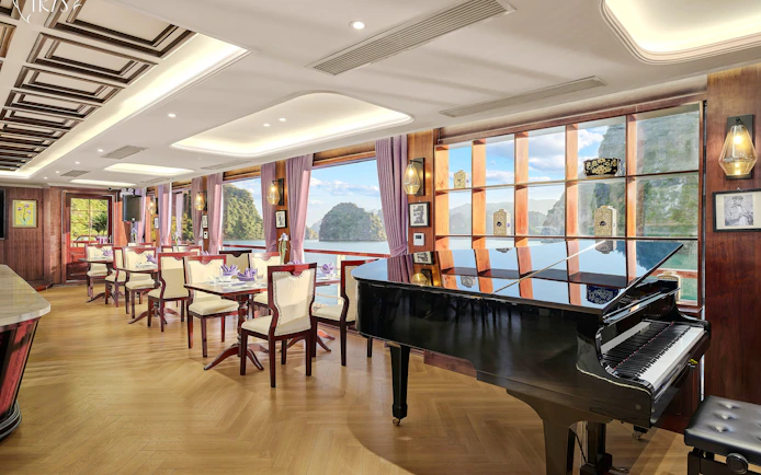 Restaurant 2nd deck with grand piano on Iris Luxury Cruise, Ha Long Bay views.