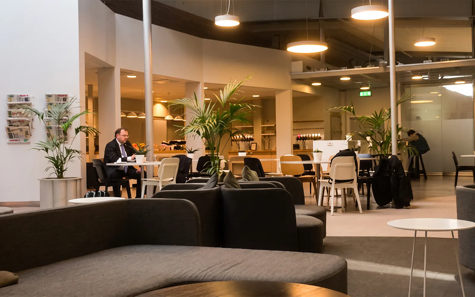 Pearl Lounge seating area with tables and plants at Stockholm Arlanda Airport Terminal 2.