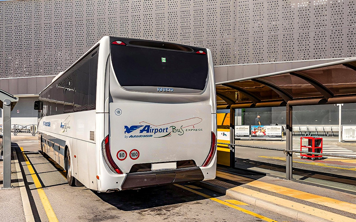Airport bus at Malpensa Airport terminal for Milan Central Station route.