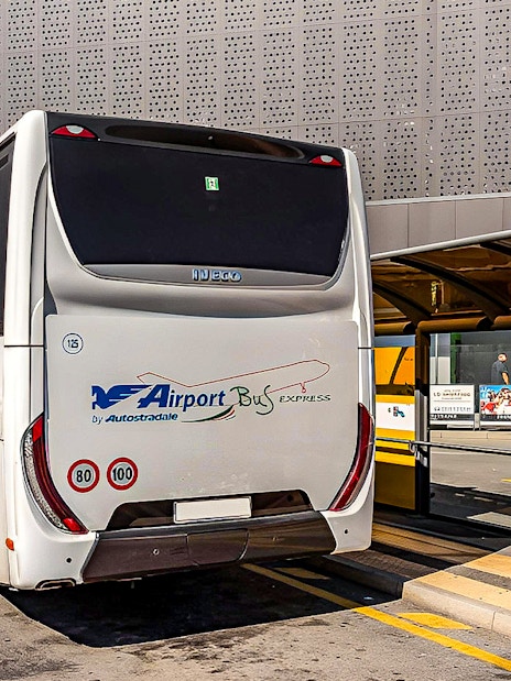 Airport bus at Malpensa Airport terminal for Milan Central Station route.