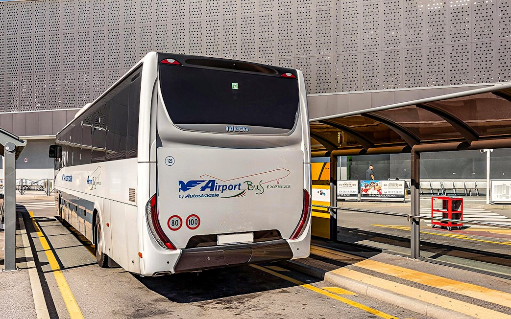 Autostradale Airport Transfer bus parked at airport terminal.