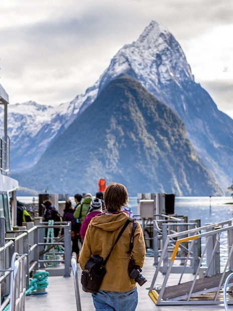 Cruise passengers on deck with view of Mitre Peak, Milford Sound, New Zealand.