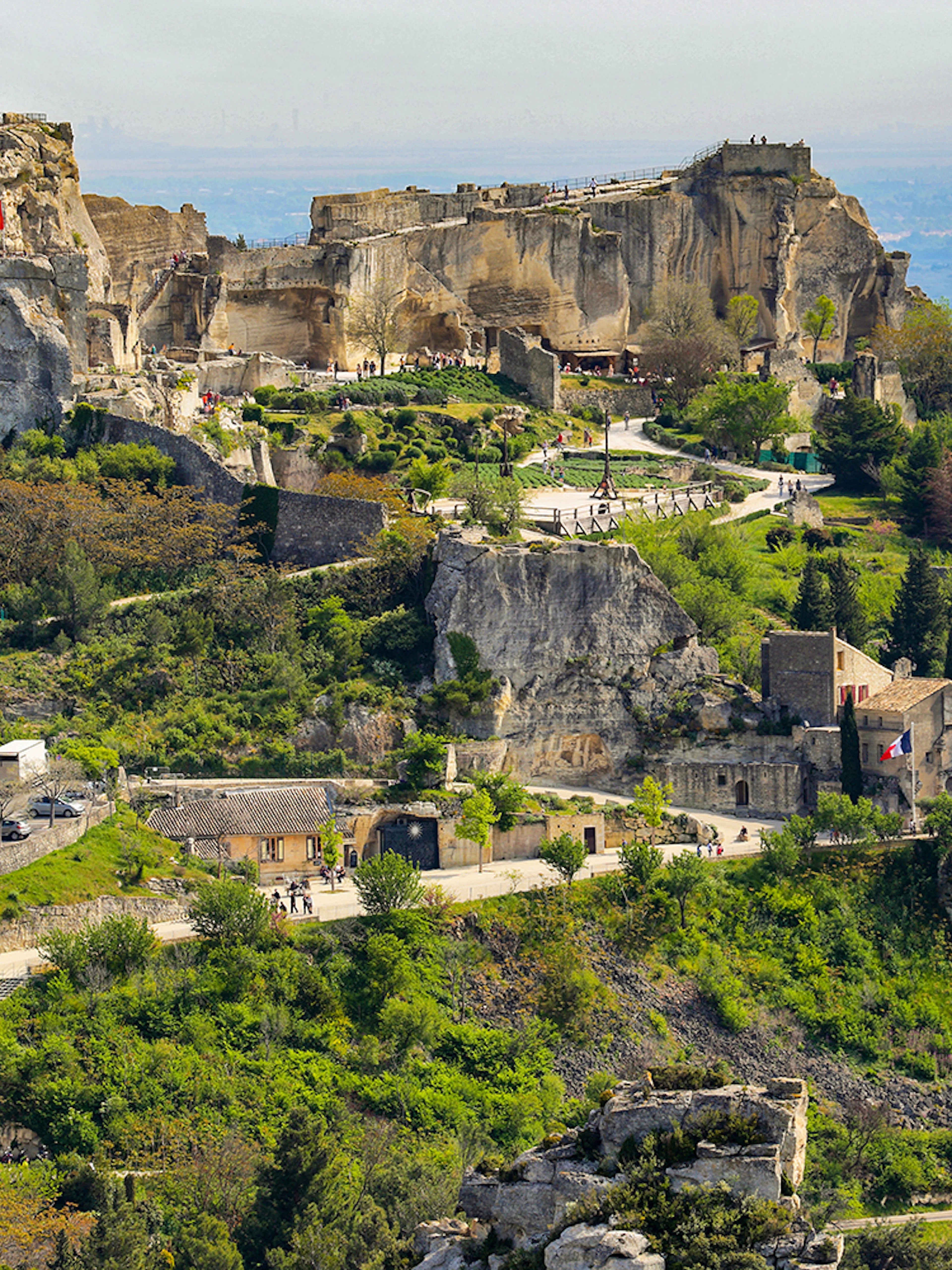 Les Baux de Provence village with ancient stone buildings and surrounding greenery.