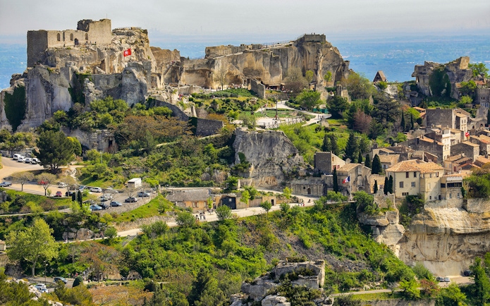 Les Baux de Provence village with ancient stone buildings and surrounding greenery.