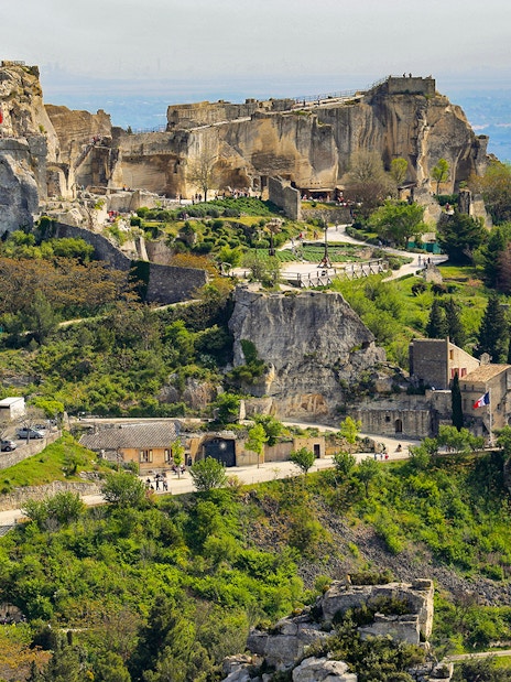 Les Baux de Provence village with ancient stone buildings and surrounding greenery.