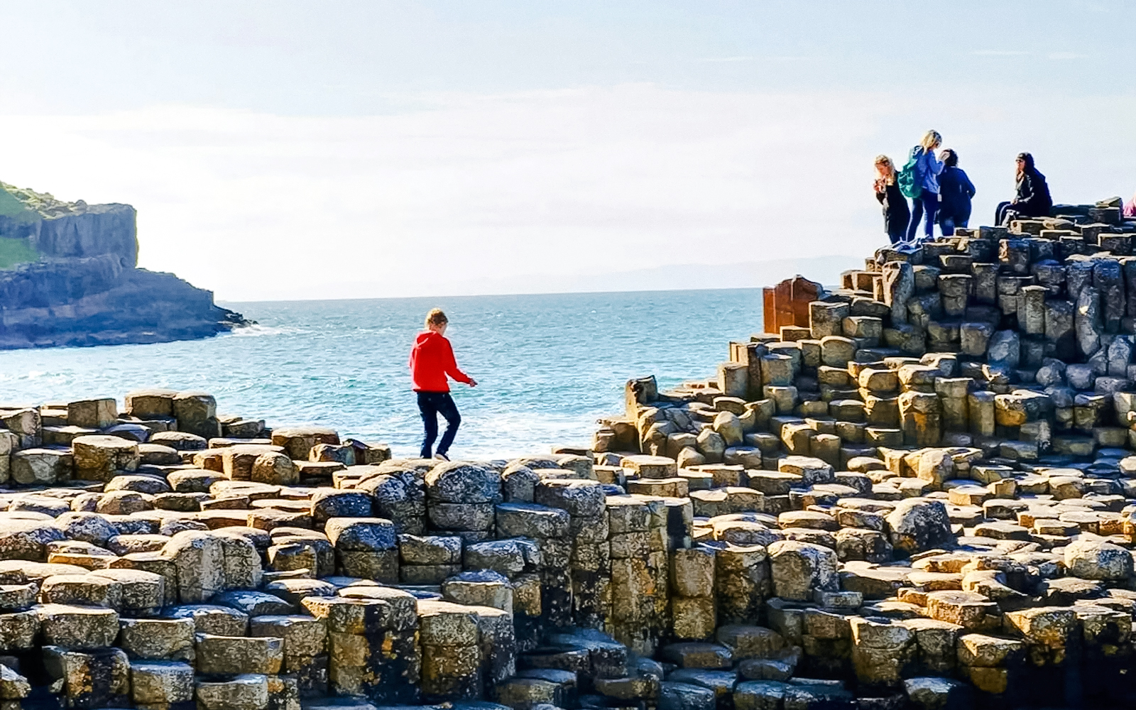 Visitors exploring basalt columns at Giant's Causeway, Northern Ireland.