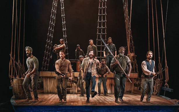 Actors performing a nautical scene on stage with ship rigging, related to "Swept Away.