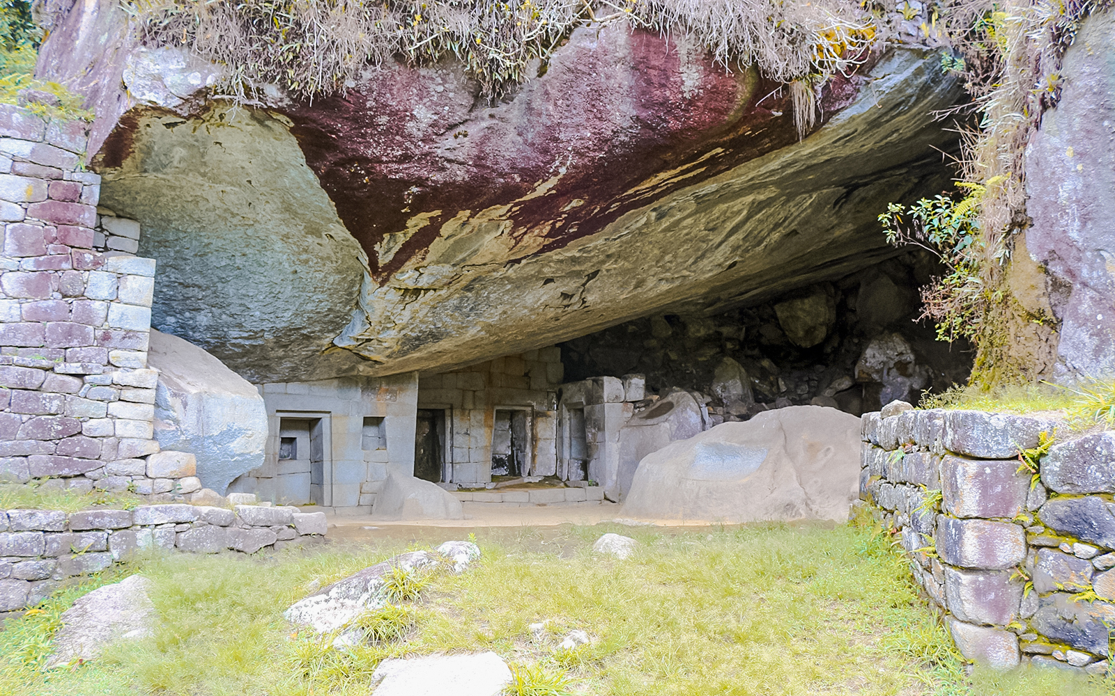 Moon Temple stone structure at Machu Picchu with carved niches and natural rock formations.