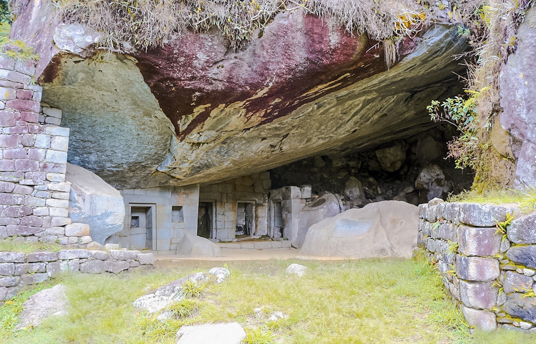 Moon Temple stone structure at Machu Picchu with carved niches and natural rock formations.