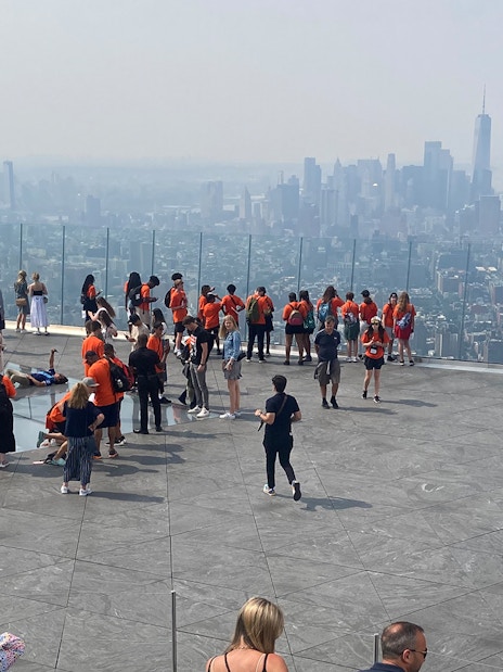 Visitors at Edge Observation Deck in NYC overlooking Manhattan skyline.