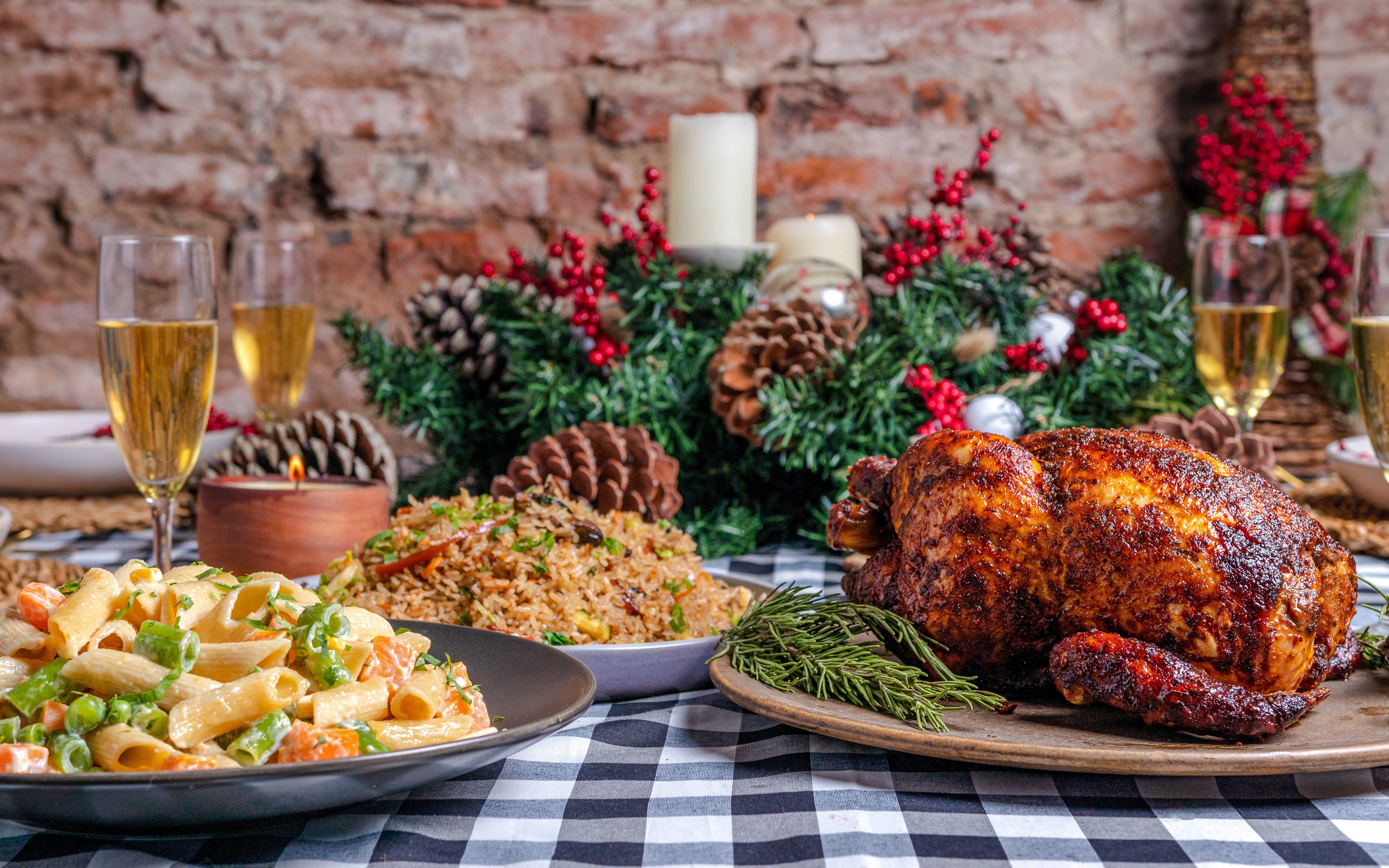 Creole Christmas meal with roasted chicken, pasta, and rice on a festive table setting.
