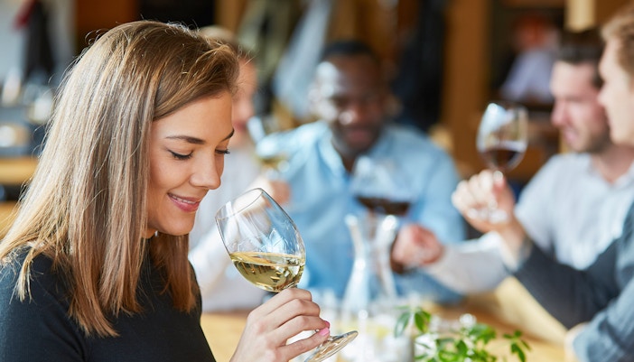 Young woman tasting white wine during Harvest Festival at Clos Montmartre