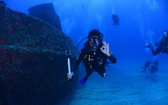Scuba diver exploring shipwreck in Sharm El Sheikh with guided group.