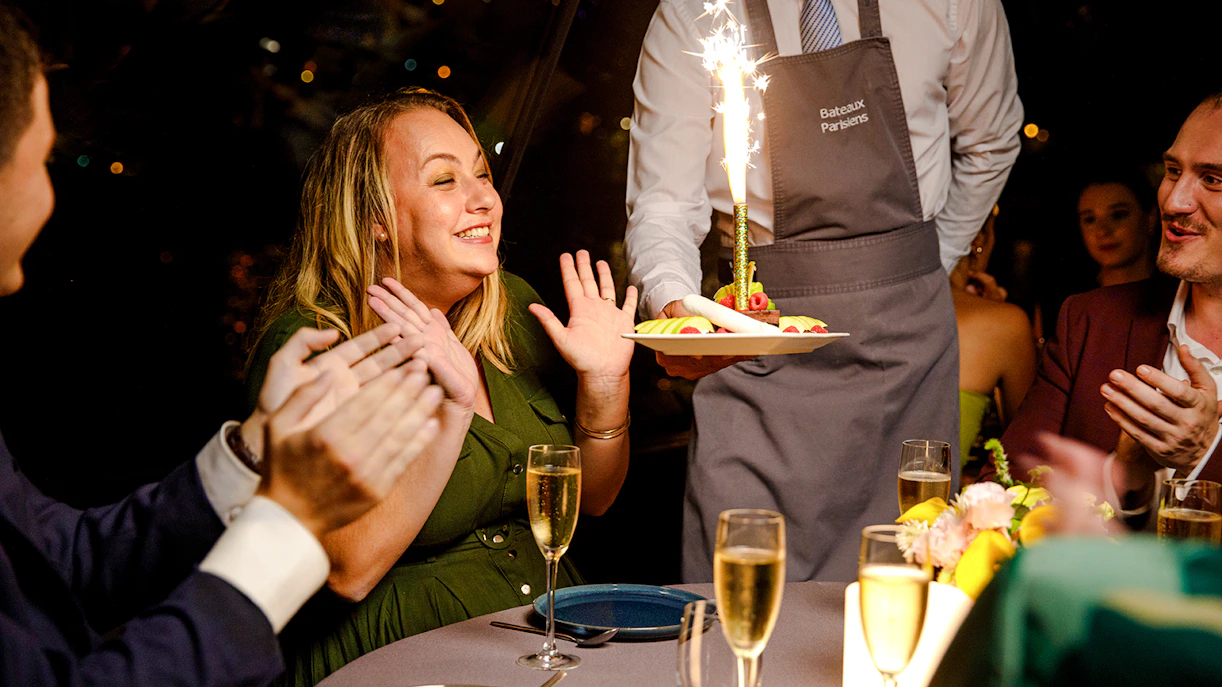 Seine River cruise guests celebrating with dessert and sparklers.