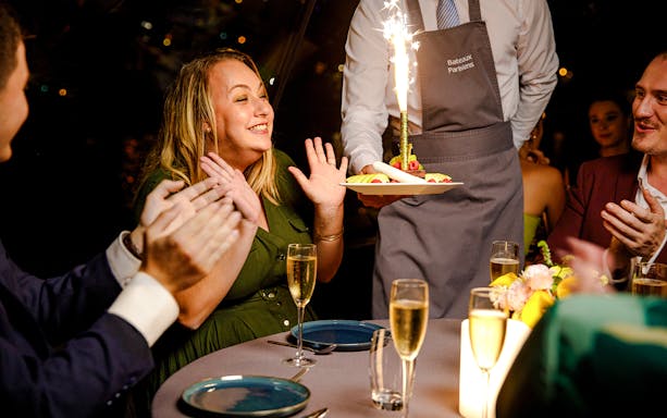 Seine River cruise guests celebrating with dessert and sparklers.