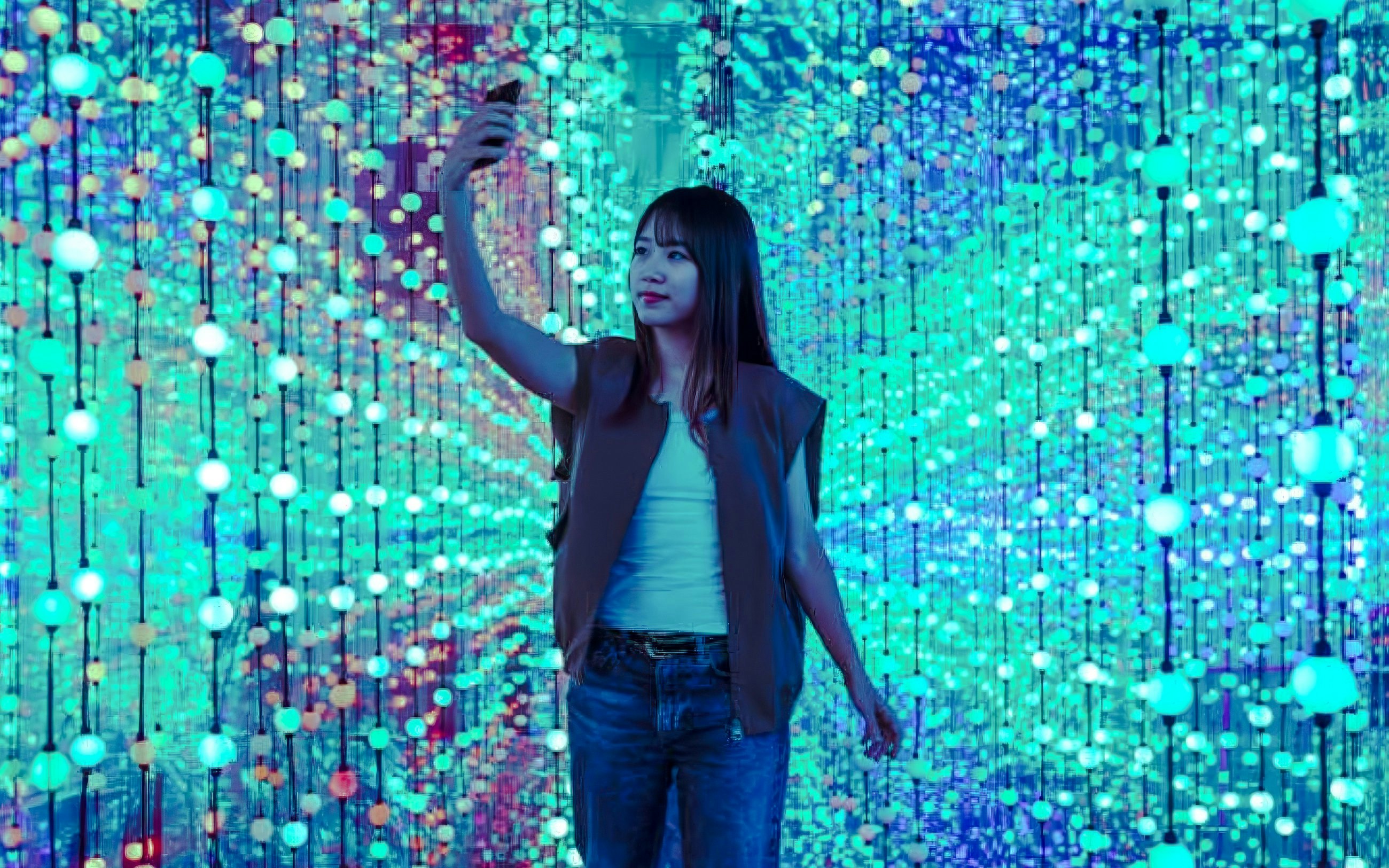 Girl taking a selfie in Dopamine Land's immersive light display.