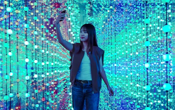 Girl taking a selfie in Dopamine Land's immersive light display.